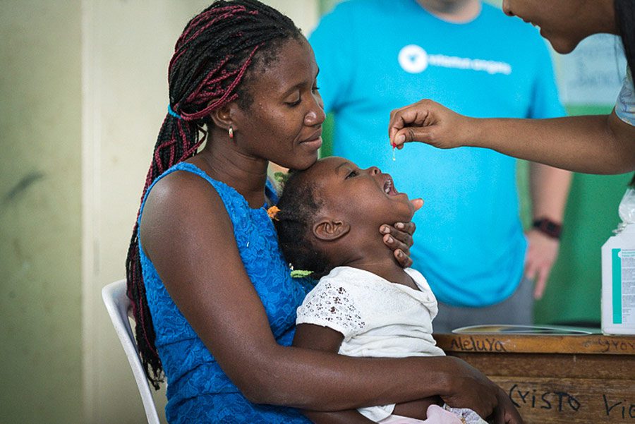 mother holding child receiving vitamin a uganda