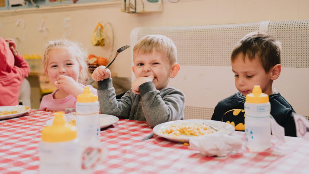 children feeding program kids eating at table