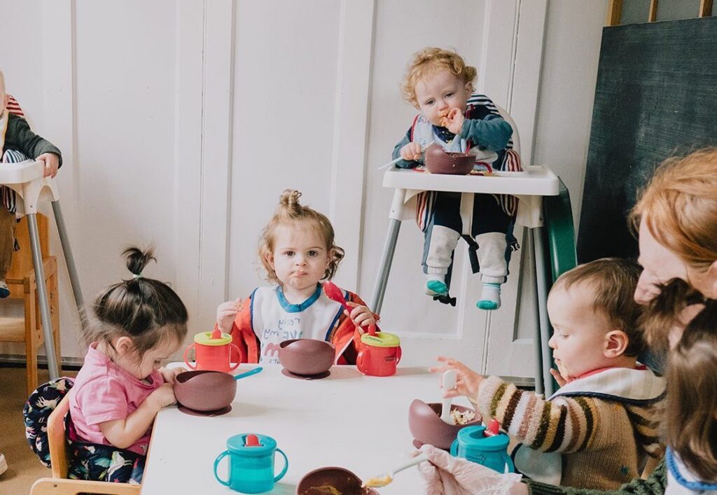 toddlers eating together at nursery in united kingdom