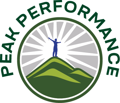 Round logo for Peak Performance. Illustration of an all blue person standing on top of green hills with a white sunburst behind the blue person on a grey background. The words c