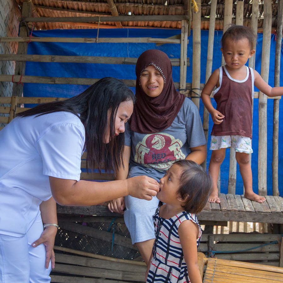 A young child receives a dose of vitamin A