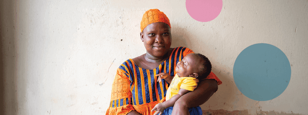 Mother in orange holding infant child.