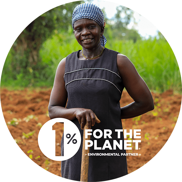 Portrait of a woman standing in a farm with the 1% for the Planet logo.