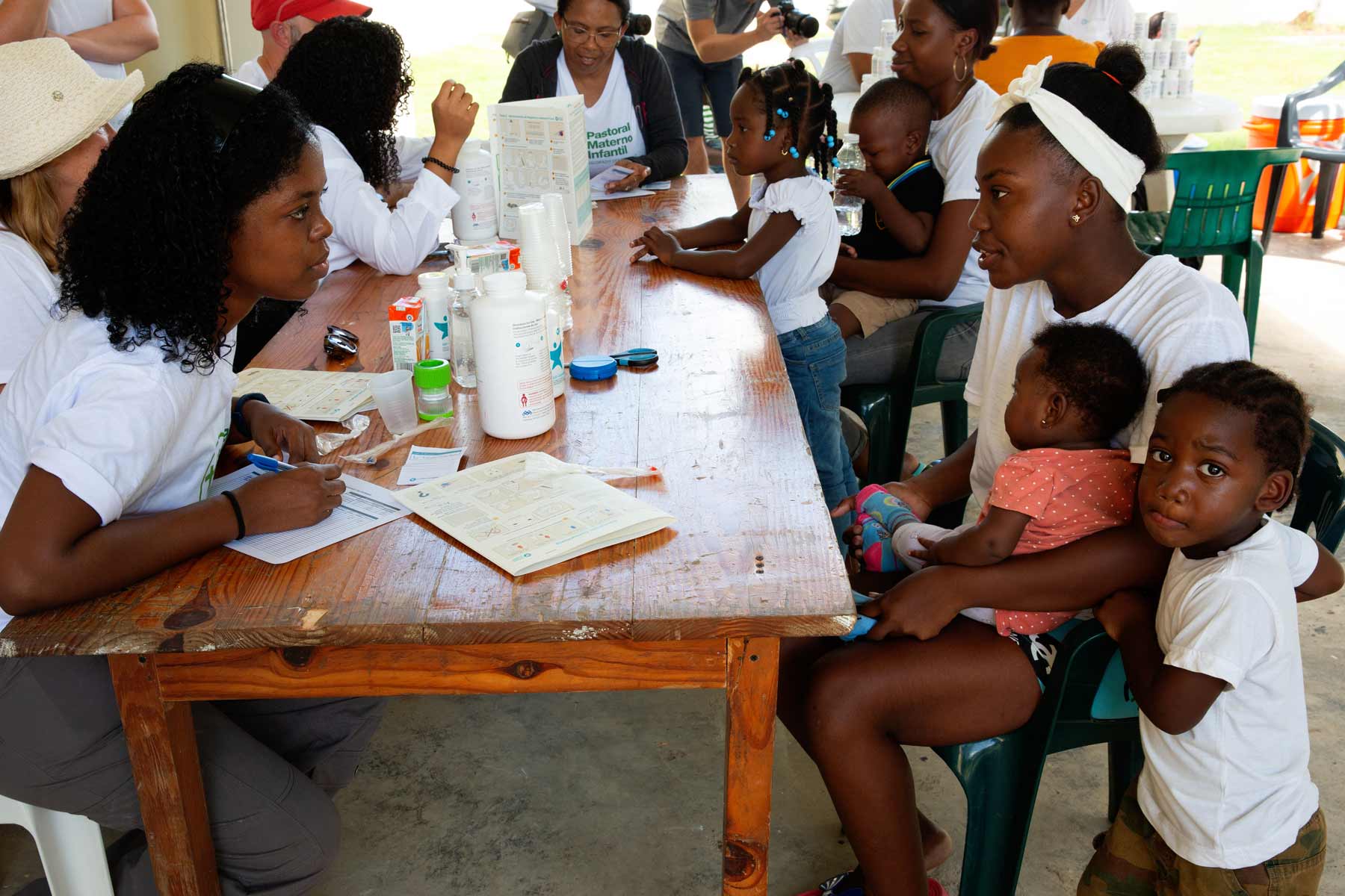 A group of health providers and patients sit around a table.