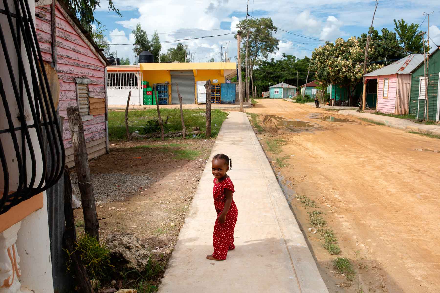 A young girl standing on the sidewalk