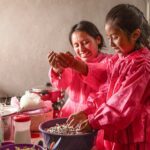 A mother and her five-year-old daughter sort corn in their kitchen in Mexico.