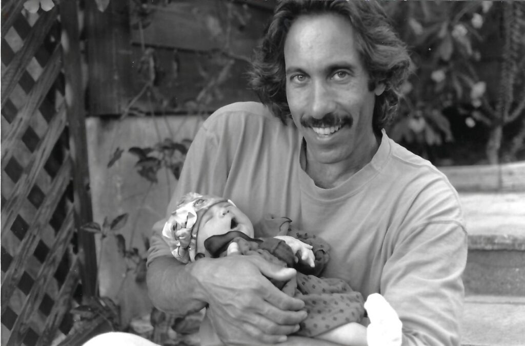 A black and white image of Howard Schiffer holding his infant daughter.