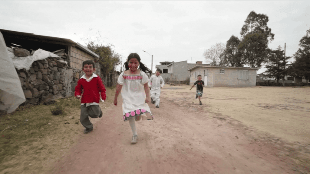 A thumbnail from a video of young children running along a dirt road in Mexico.