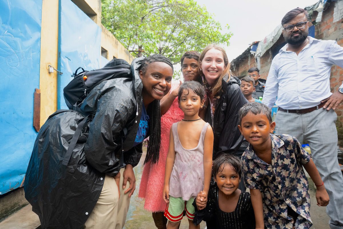 Smarty Pants employees posing with young children on a trip to India.